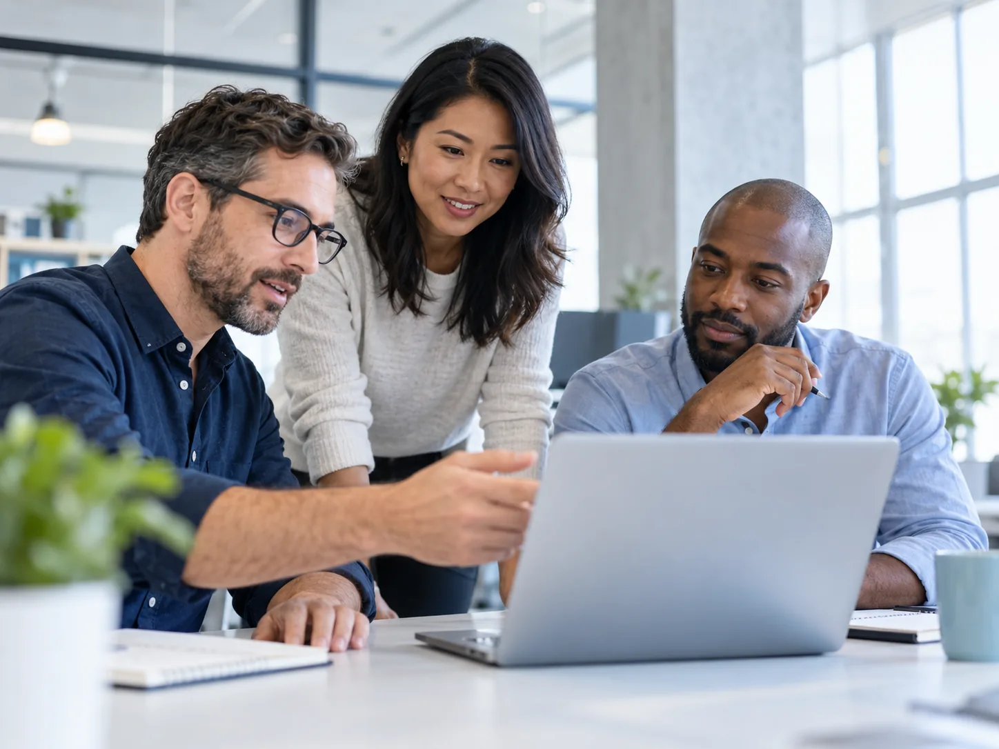 Engineers collaborating around a laptop (illustrative image)